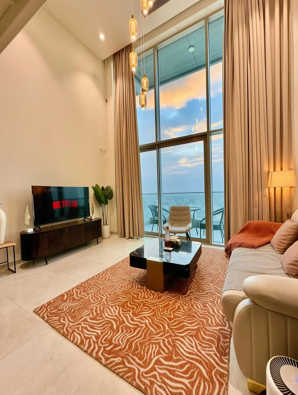 Double-height living room with floor-to-ceiling windows and city view