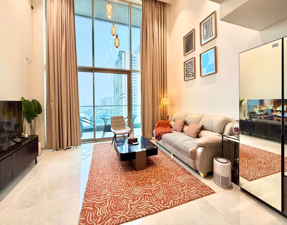 Living room with sofa, rug and tall curtains