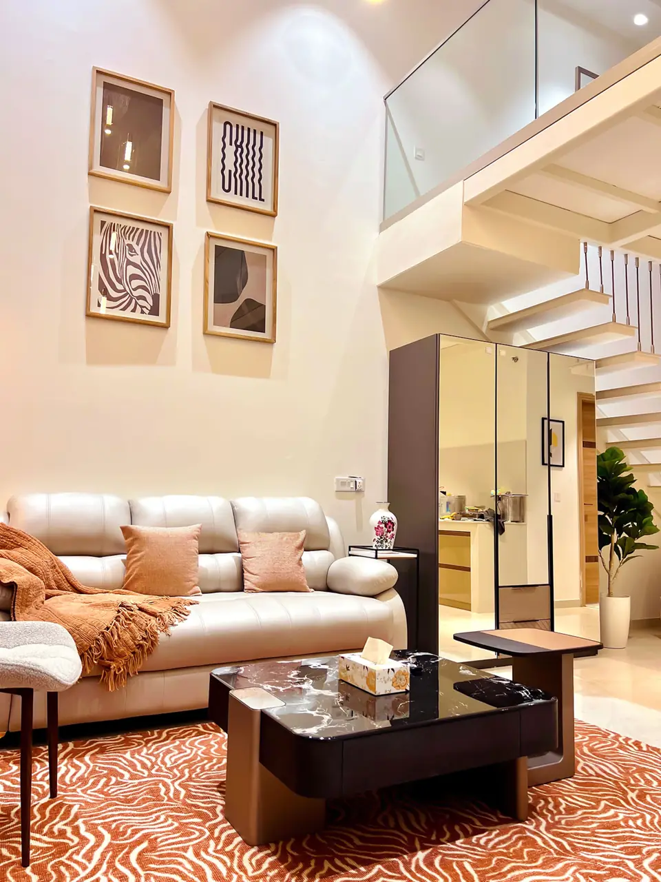 Sofa corner with framed art and staircase to the loft