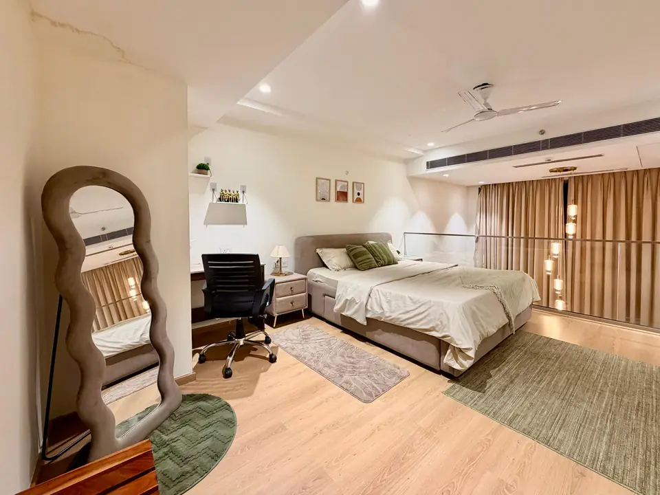 Loft bedroom with king bed, mirror and desk